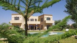 A modern two-story building with a swimming pool in the foreground. - Pleasant villa with swimming pool in Marrakech 5100 (Marrakech)