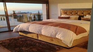 A bedroom with a large bed, a view of the sea, and a balcony. - Superb villa with swimming pool in Taghazout Bay 5101 (Taghazout)
