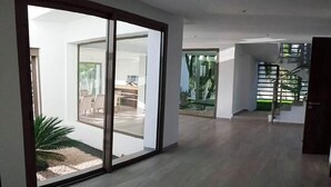 A spacious interior with a large sliding glass door leading to an outdoor area, a staircase, and a view of a dining area. - Superb villa with swimming pool in Taghazout Bay 5101 (Taghazout)