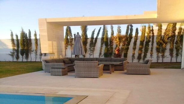 A modern outdoor patio with a pool, wicker furniture, and a pergola. - Superb villa with swimming pool in Taghazout Bay 5101 (Taghazout)