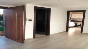 A modern interior with a wooden door, a kitchen area, and a hallway. - Superb villa with swimming pool in Taghazout Bay 5101 (Taghazout)
