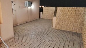 Une terrasse sur le toit dotée d’un plancher perforé, d’un climatiseur fixé au mur et d’un mur en treillis.