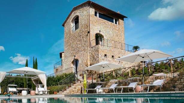 A stone tower hotel with a swimming pool, lounge chairs, and umbrellas. - Private Villa with private pool, A/C, WIFI, sauna, hot tub, TV, patio, close to Greve In Chianti (Radda In Chianti)