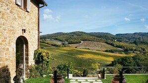 A stone building with a view of vineyards and hills. - Private Villa with private pool, A/C, WIFI, sauna, hot tub, TV, patio, close to Greve In Chianti (Radda In Chianti)
