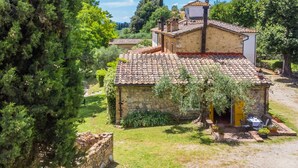 A rustic stone house with a tiled roof, surrounded by greenery and trees. - Beautiful apartment in villa for 6 people with pool, TV and patio (Poggibonsi)