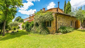 A stone house with a garden, a bench, and a clear blue sky. - Nice apartment in villa for 4 people with pool, TV and patio (Poggibonsi)