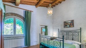 A bedroom with a bed, a window, a hanging light fixture, and a painting on the wall. - Nice apartment in villa for 4 people with pool, TV and patio (Poggibonsi)