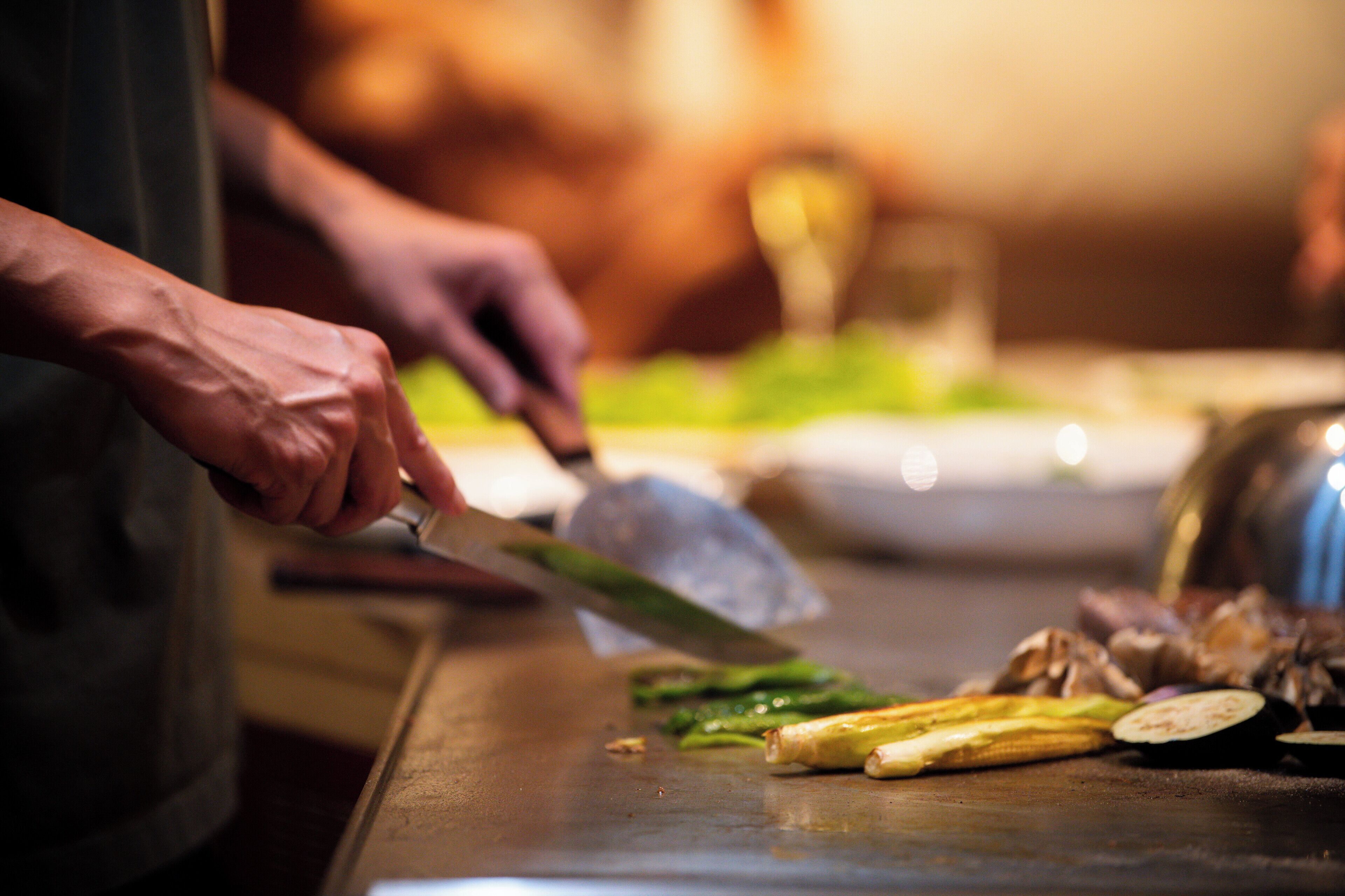 A person slicing vegetables on a cutting board.