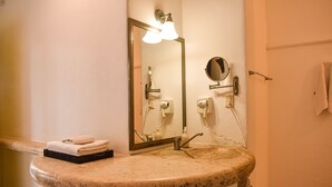 A bathroom with a granite sink, a mirror, a towel rack, and a towel hanging on the wall. - Master Room on 5th, one block to the beach (Playa del Carmen)