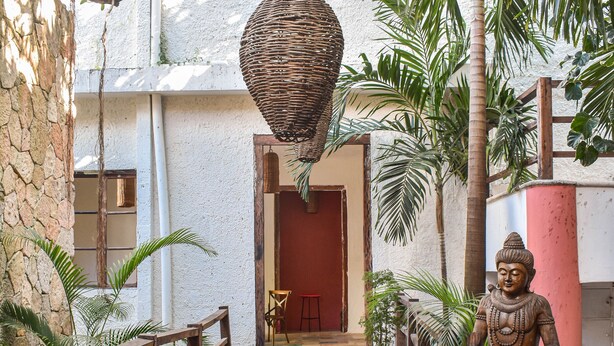 A stone pathway leading to a building entrance, flanked by wooden railings and potted plants. - Master Room on 5th, one block to the beach (Playa del Carmen)