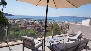 A balcony with a table and chairs, overlooking a marina and coastal town. - Villa Magnifica, L'Estartit - Center (Estartit (L´))