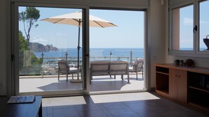 A room with a sliding glass door leading to an outdoor seating area with a view of the sea. - Villa Magnifica, L'Estartit - Center (Estartit (L´))