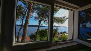 A window with a view of a lake, trees, and a distant island. - Modern apartment on the beautiful Croatia coast (Prižba)