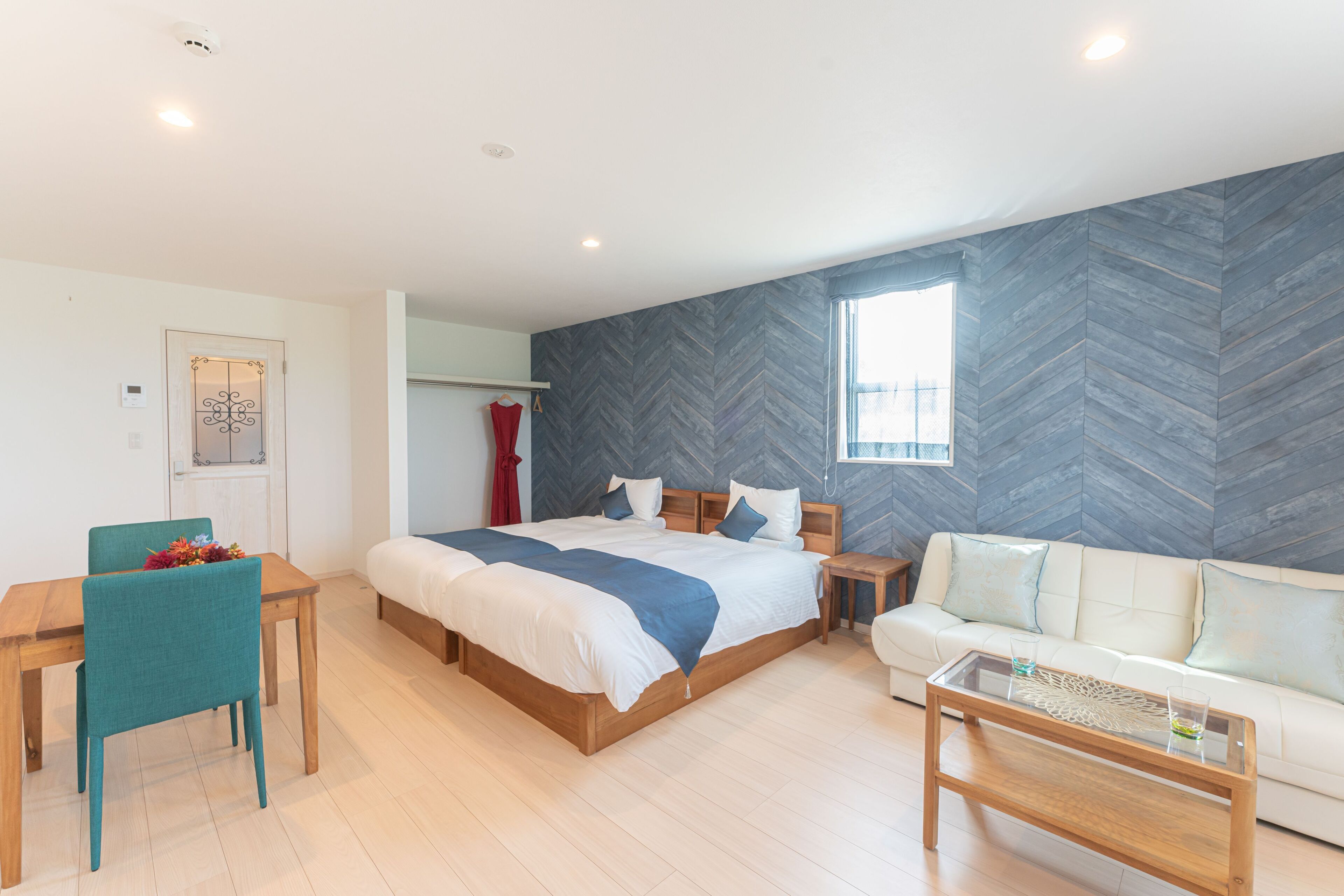 A modern bedroom with a large bed, a sofa, a dining table, and a coffee table.