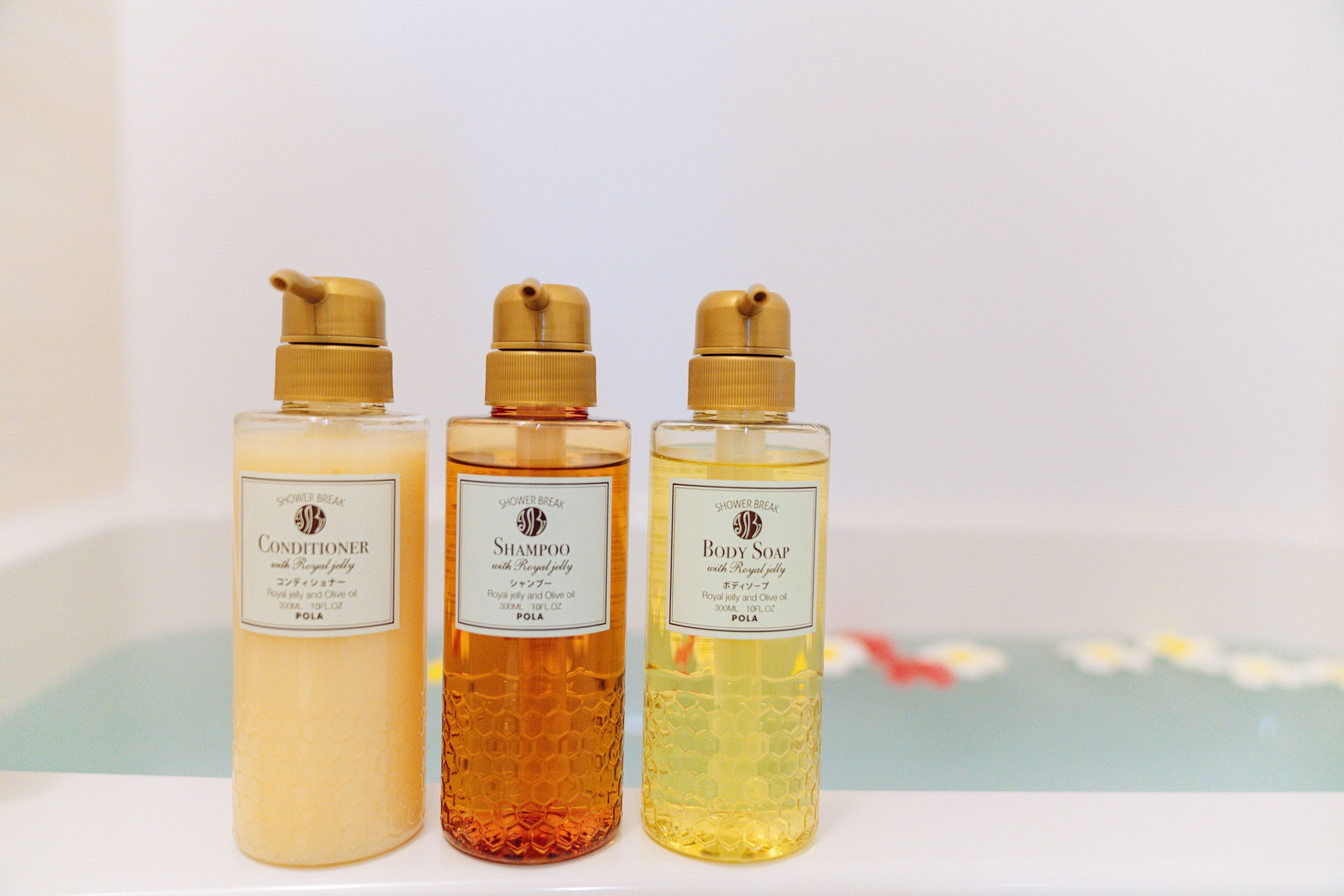 Three bottles of shower products on a shelf.