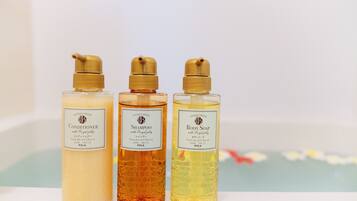 Three bottles of shower products on a shelf.
