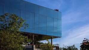 En moderne bygning med en spejlenende glasfacade og et fladt tag.