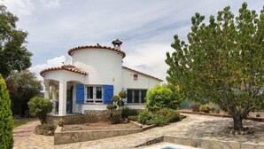 A white villa with a swimming pool, stone pathway, and a large tree in the garden. - Vacation home Ami by Interhome (Calonge)