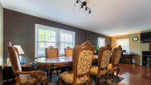 A dining room with a wooden table and chairs, large windows, and a fireplace. - Single family dream in the hearth of FAIRFAX VA (Fairfax)