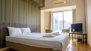A hotel room with a large bed, a TV on a stand, a chair, and a window with curtains. - S-Presso Namba Parks Street  (Osaka)