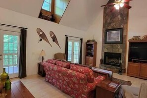 Cozy living space with a fireplace, sofa, coffee table, and TV.