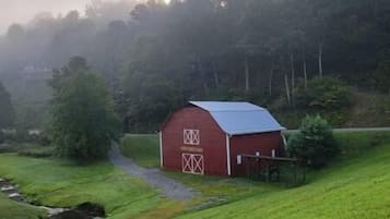 Ein rotes Bauernhaus mit Metalldach, einer Holztür und einem kleinen Anbau.
