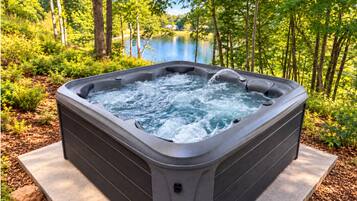 Relax in the private hot tub with tranquil lake views and wooded surroundings
