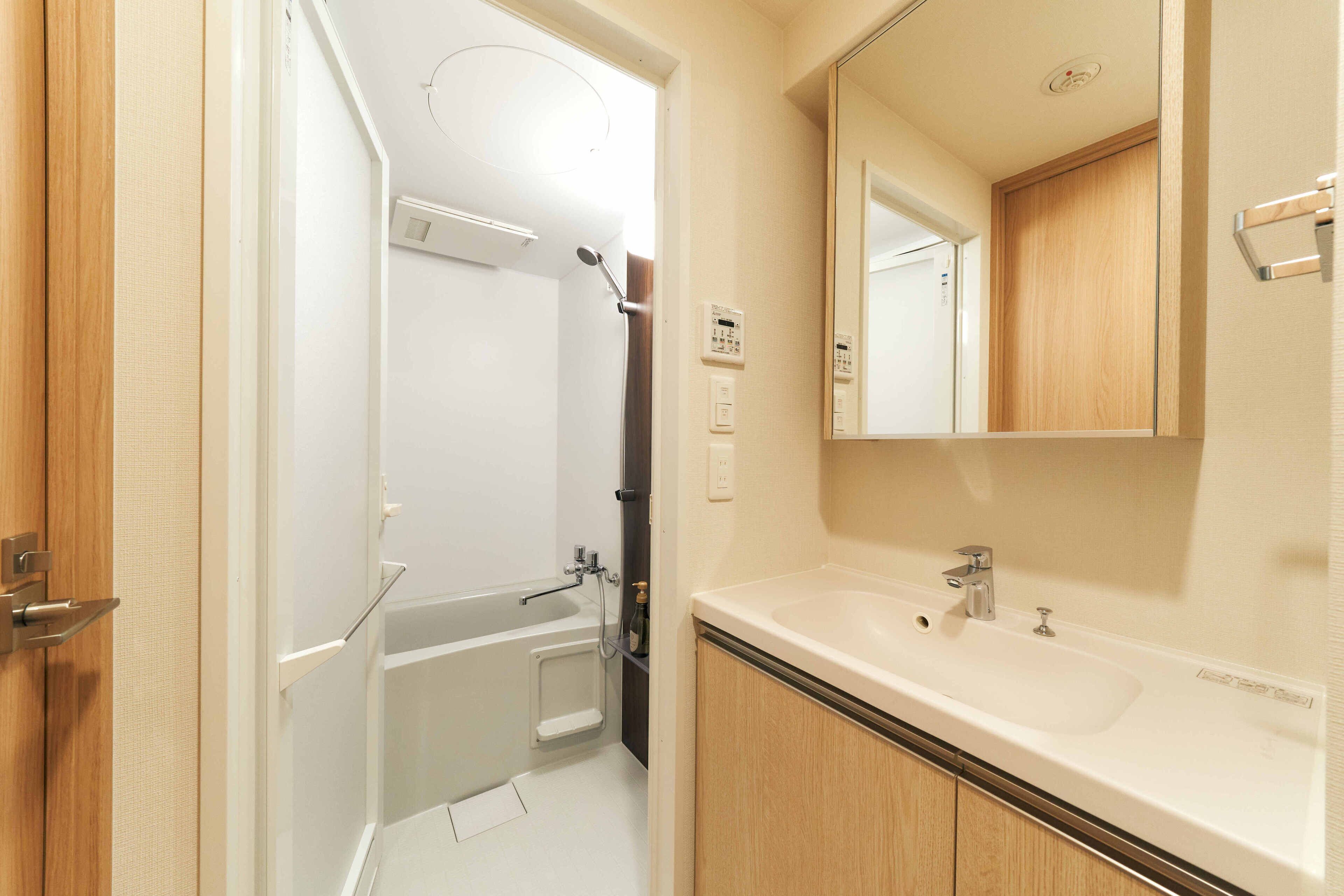 A bathroom with a white sink, a mirror, and a shower.