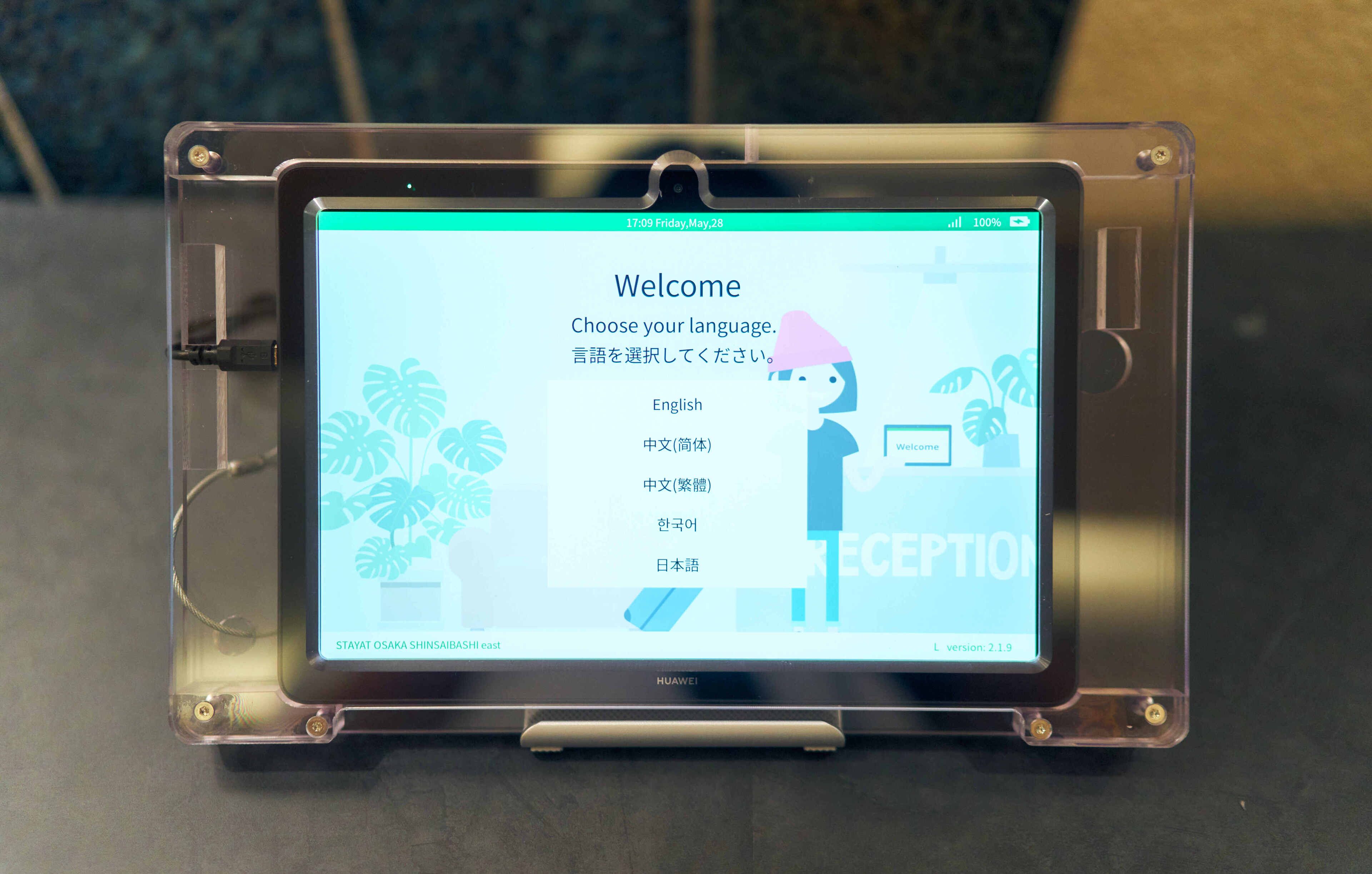A digital kiosk with a touchscreen interface displaying a language selection menu.