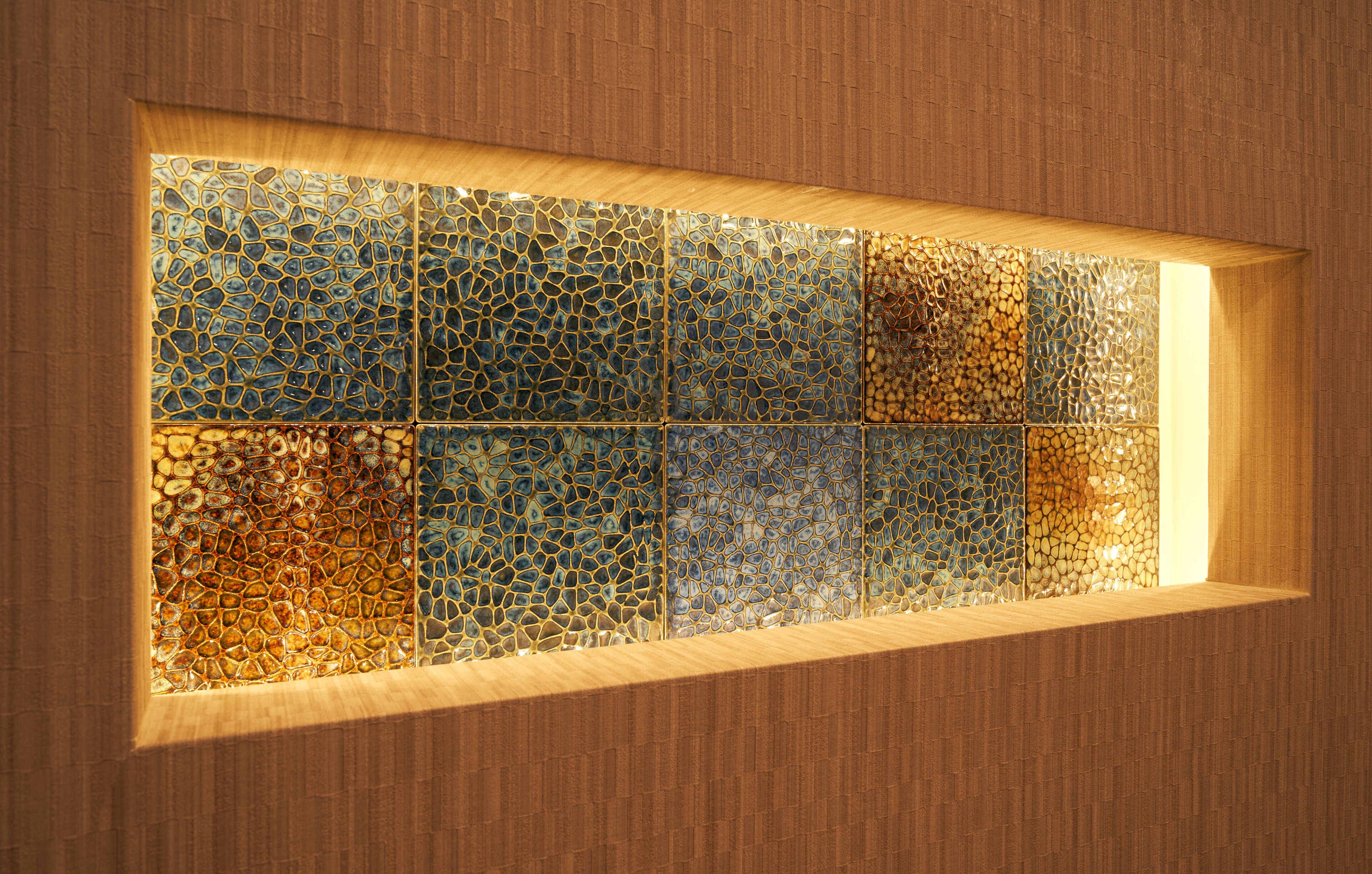 A wall with a mosaic tile design.