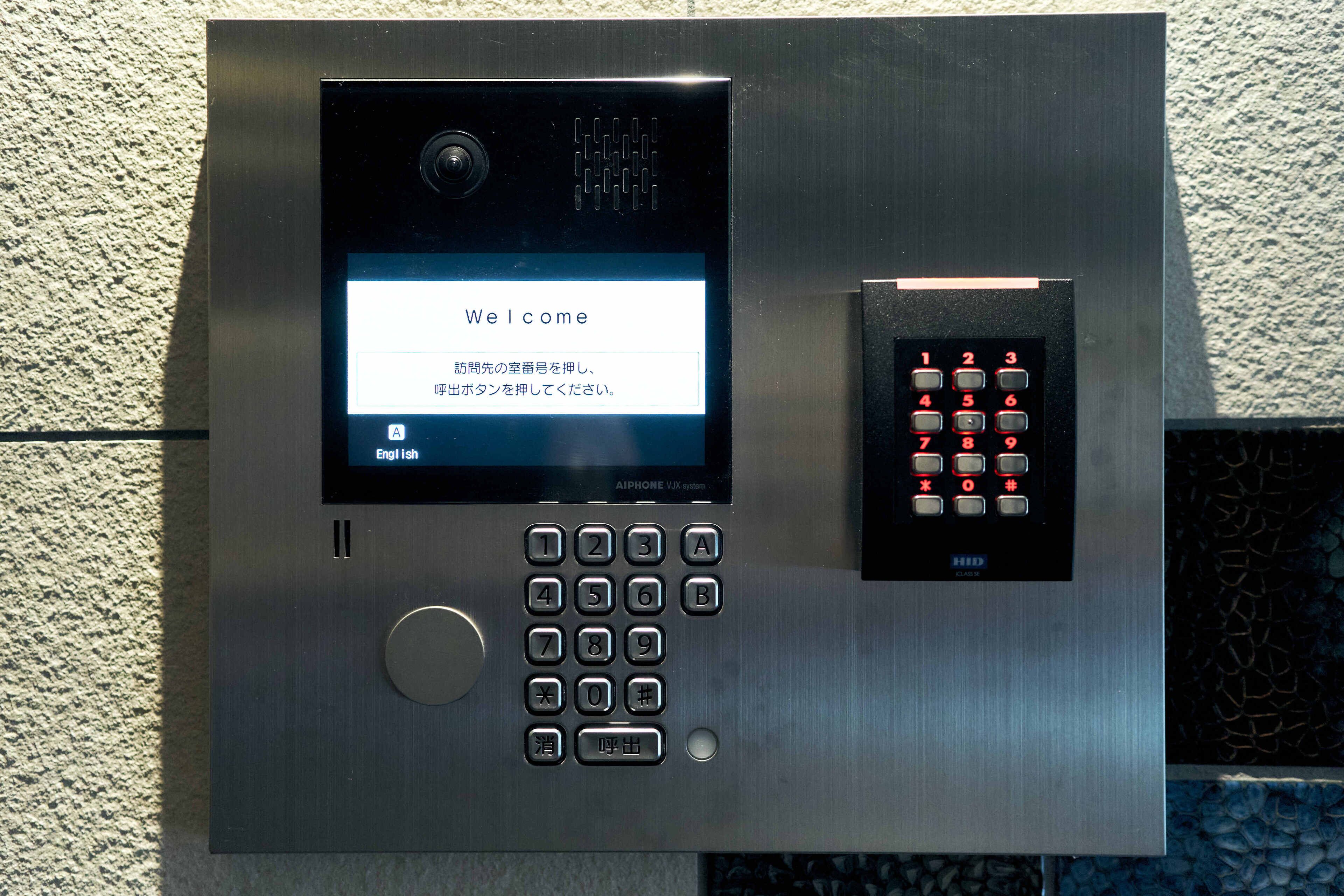 A modern elevator control panel with a digital display, keypad, and emergency call button.