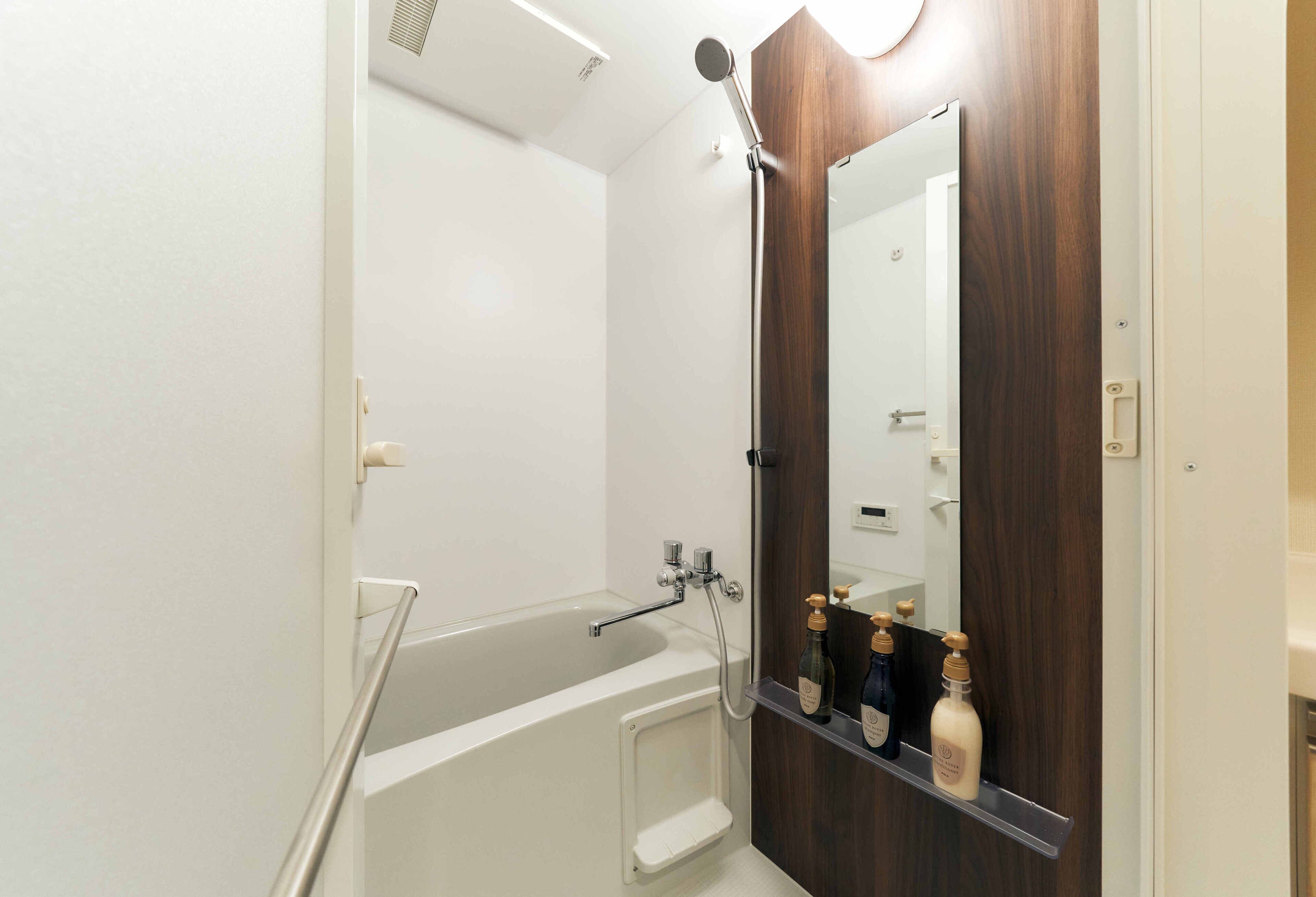 Un bagno moderno con vasca, doccia e un mobile bagno in legno con specchio.