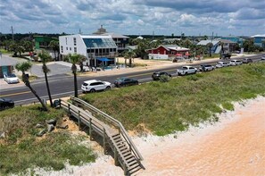 Une route côtière avec une promenade en bois qui mène à une plage.
