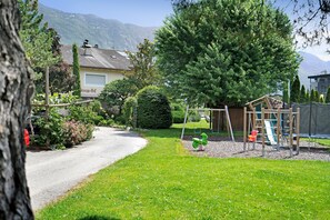 Un quartier résidentiel avec une rue, une aire de jeux et un bâtiment dont l’enseigne est bien visible.