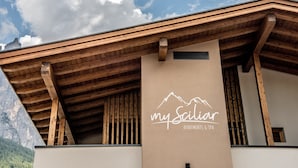 A building with a wooden facade and a sign that reads 'my Sailiar Apartments & Spa.'