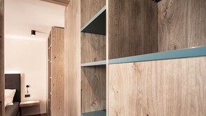 Een houten garderobe met planken, een nachtkastje en een bed.