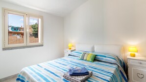 A bedroom with a bed, two bedside lamps, a window, and a view of the outside. - Villa Casa Angus with partial Sea View, A/C, Garden & Terrace; Pet-friendly (BADESI)