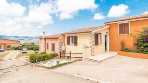 A residential area with houses, a dirt road, and a clear sky. - Villa Casa Angus with partial Sea View, A/C, Garden & Terrace; Pet-friendly (BADESI)