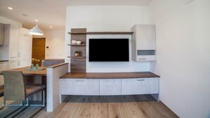 Eine moderne Küche mit integriertem Fernseher, Holzarbeitsplatten und einer Sitzbank.