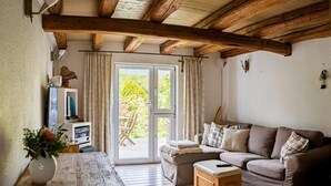 Una habitación acogedora con suelo de madera, un sofá, una mesa y un televisor.