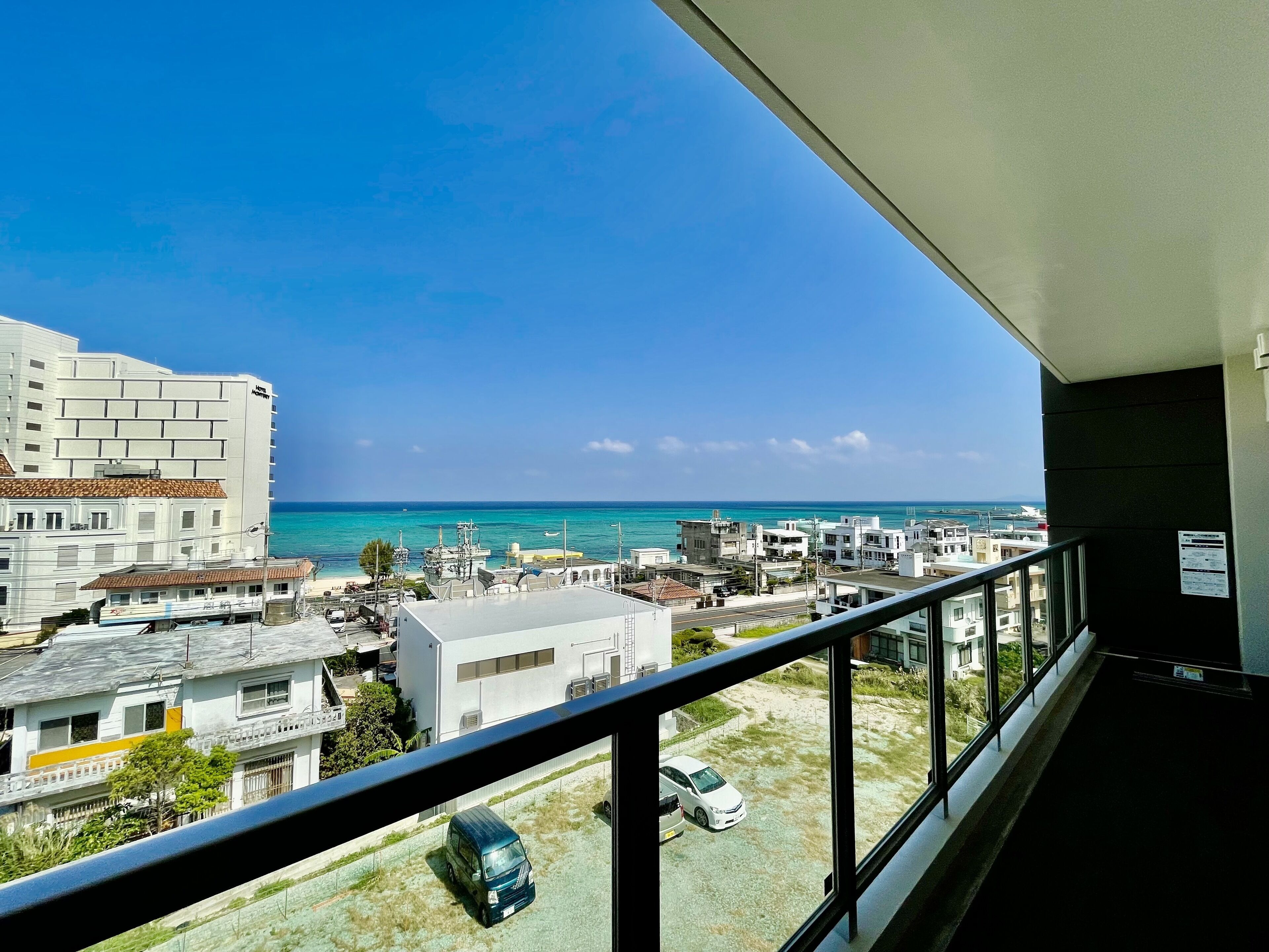 A balcony with a view of the sea and buildings.