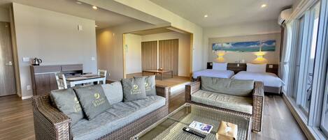 A spacious living area with a sofa set, a coffee table, and a bed with a view.
