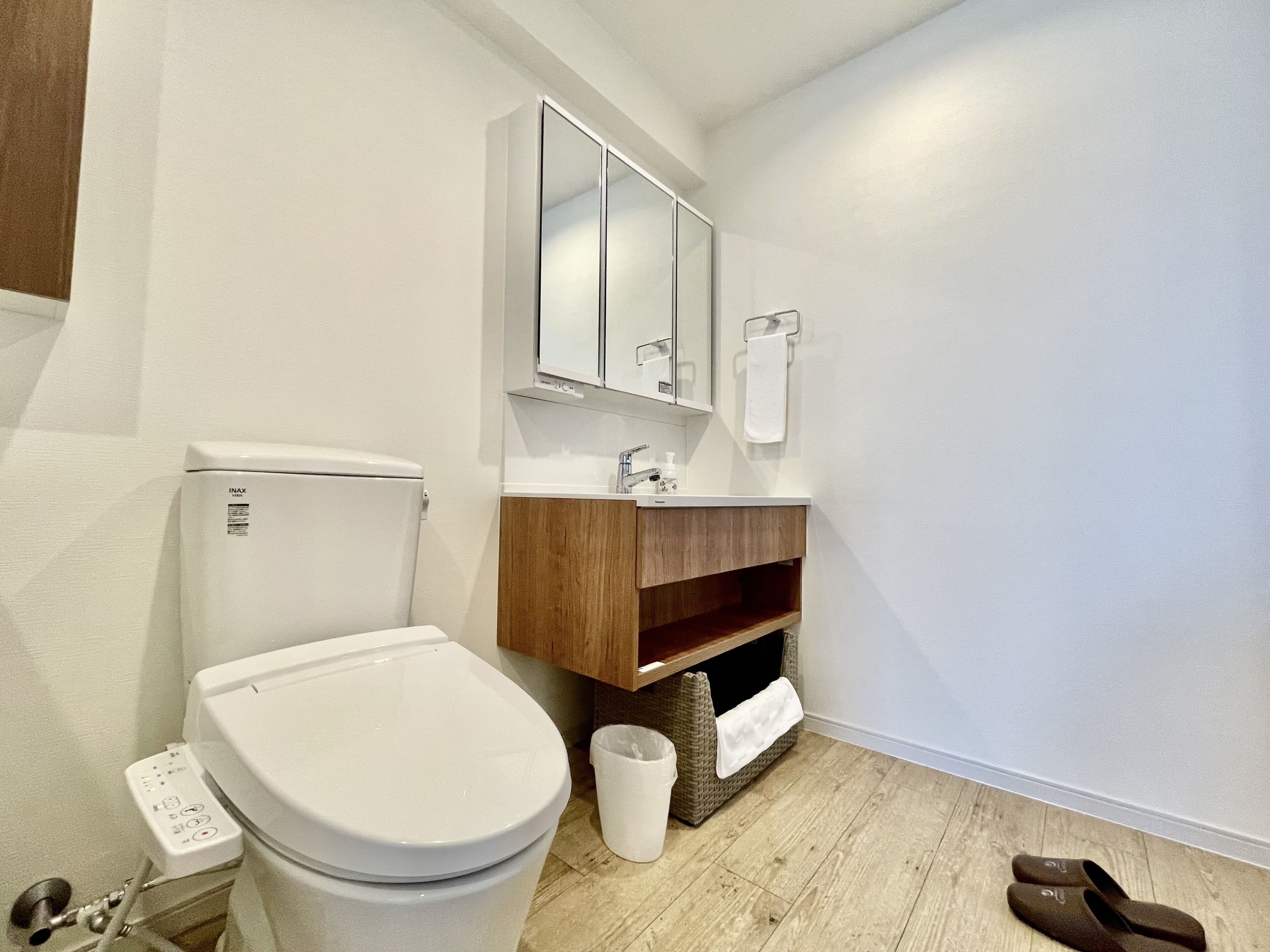 A modern bathroom with a toilet, sink, and mirror.
