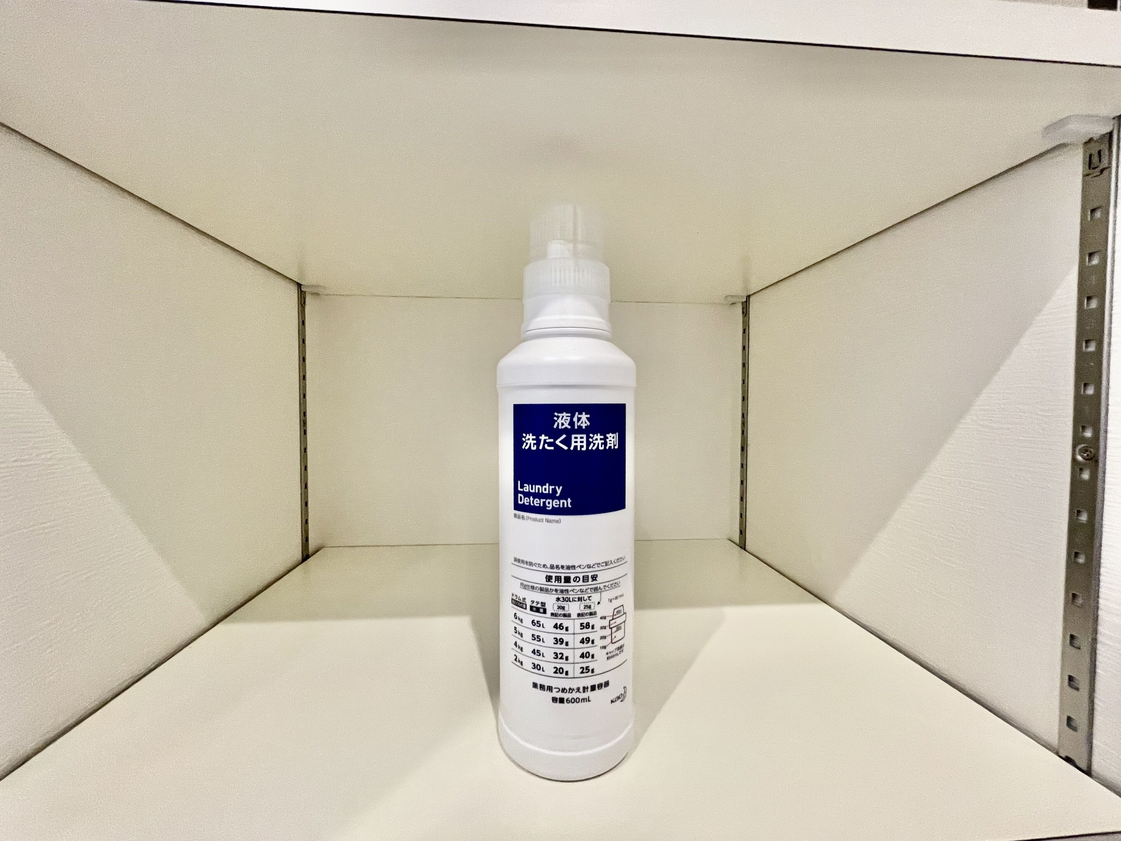 A bottle of laundry detergent in a white shelf.