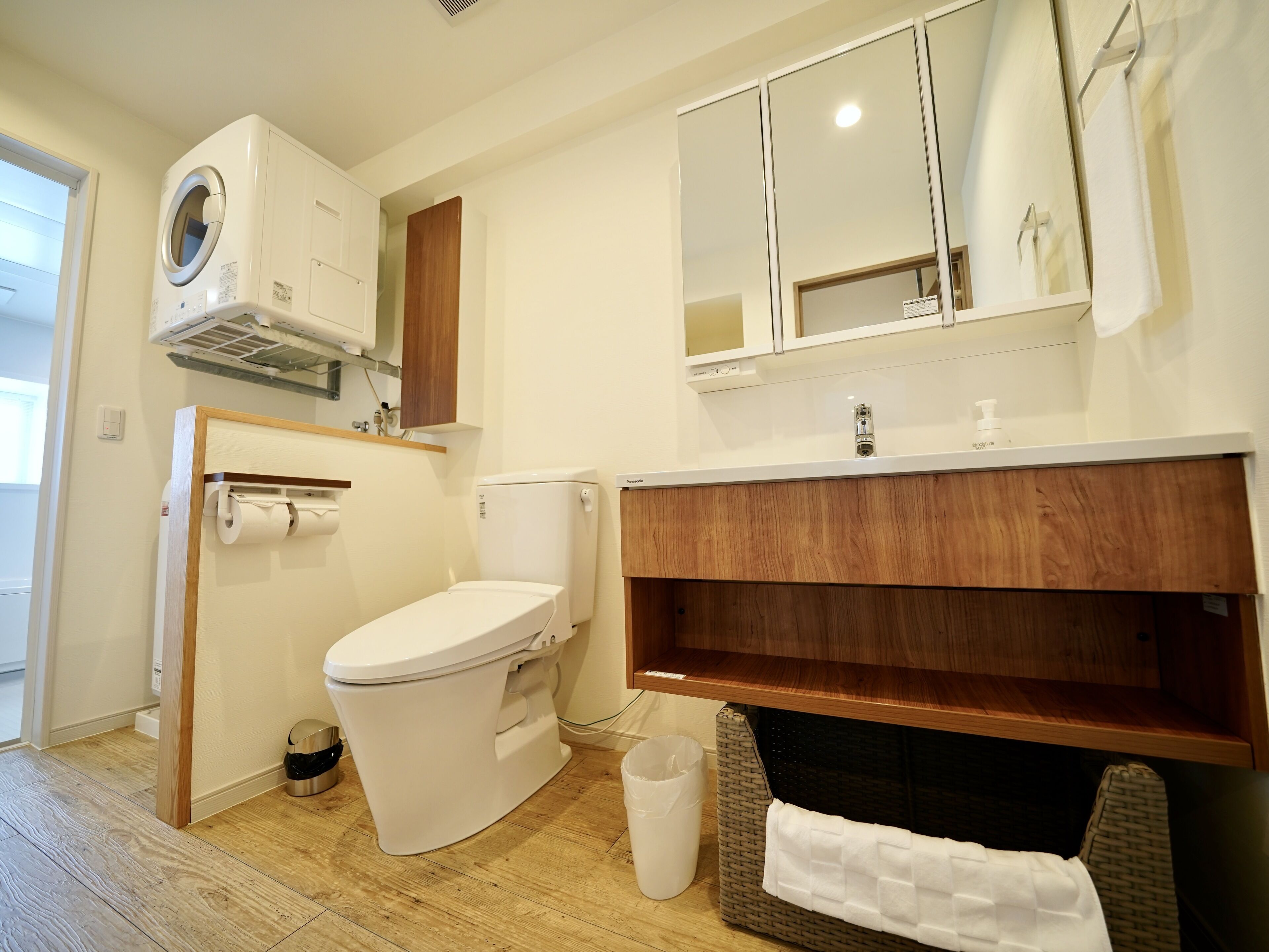 A modern bathroom with a toilet, sink, and mirror.