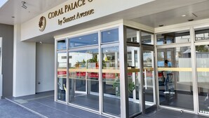 The entrance to Coral Palace Onna by Sunset Avenue with glass doors and a clear view of the interior. - Coral Palace Onna by Sunset Avenue (Onna)
