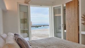 Une chambre avec un lit, une armoire en bois et vue sur la plage.