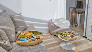 Un plateau de petit-déjeuner, un canapé et une chaise disposés dans une pièce lumineuse offrant une belle vue.