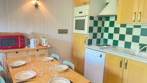 A compact kitchen with a microwave, toaster, and Bosch dishwasher. - Central Apartment in Les Gets, Steps from Village and Slopes (Les Gets)