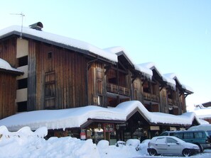 A wooden building with balconies and a sign that reads "Ski Center".
